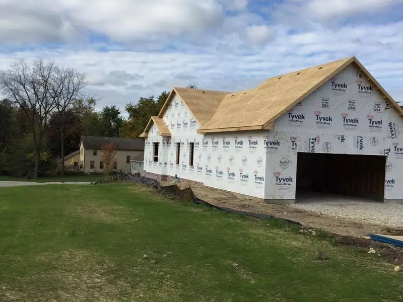 Large new home with three-car garage framed and wrapped