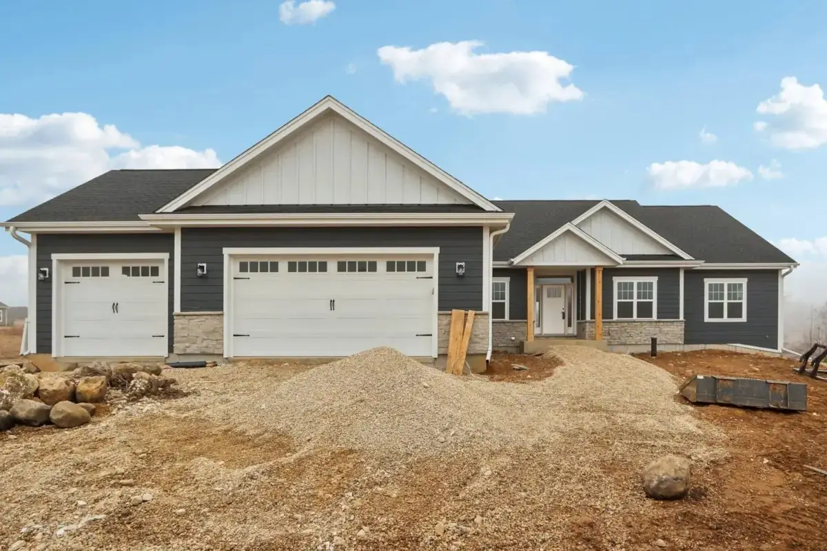Charcoal board-and-batten and lap siding over a stone wainscot on a new ranch